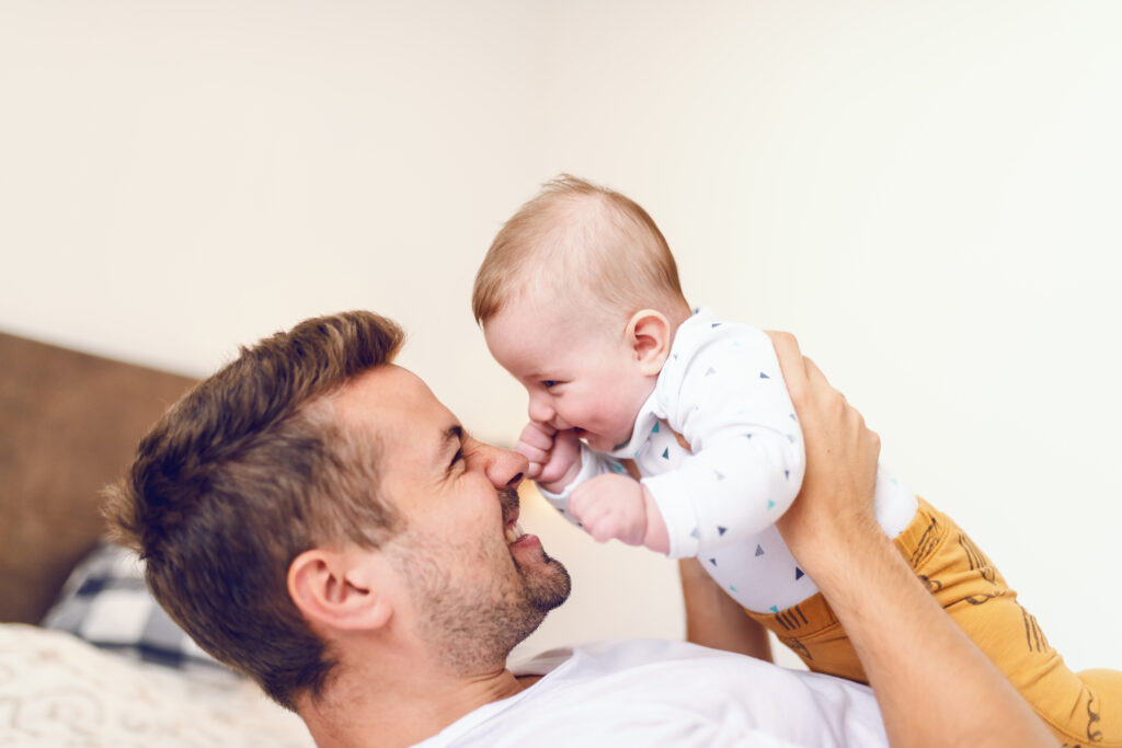 Happy father holding baby after successful vasectomy reversal in Colombia